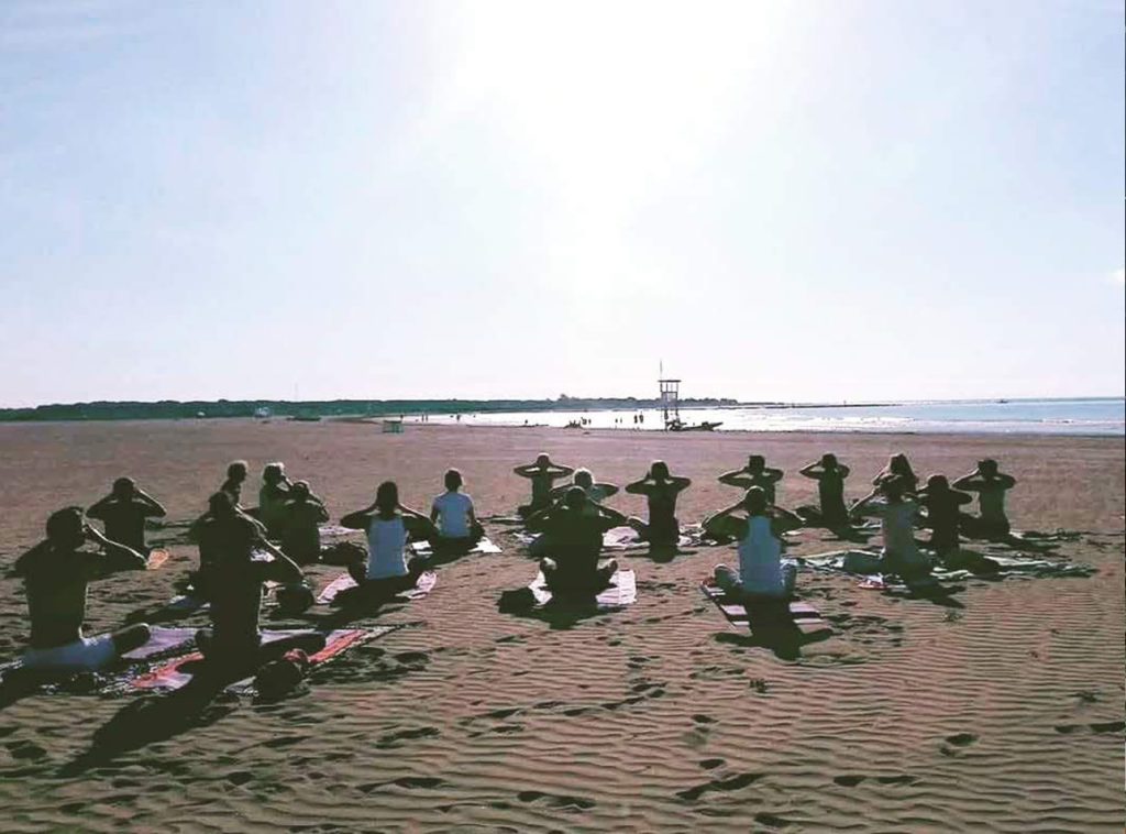 Yoga-di-gruppo-in-spiaggia-al-mare-saluto-al-sole-padova-ponte-di-brenta-niyan yoga di gruppo al mare